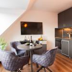 Küche mit Esstisch, Fernseher und Pflanze