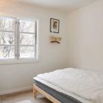 Schlafzimmer mit Bett, Fenster und Schrank.