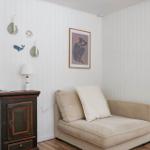 Ein Raum mit einem Sofa, einem dunklen Schrank und einer Wand mit Dekoration.