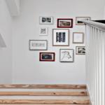 Light staircase with wooden steps and decorative wall arrangement.