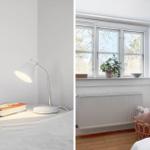 Bedroom with white nightstand, lamp, and book. Window with plant and radiator.