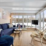 Living room with blue sofa, wooden floor, and large windows to the garden.
