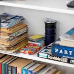 Shelf with games, magazines, and books.