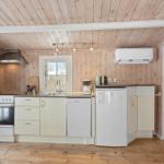 Kitchen with wooden walls, sink, refrigerator, and stove.
