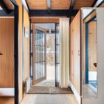 Entrance with wooden walls, door to the outside, and mirror on the wall.