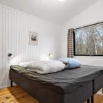 Schlafzimmer mit Bett, Fenster und Holzboden.