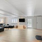Großes Wohnzimmer mit Sofa, Fernseher und Kaminofen.