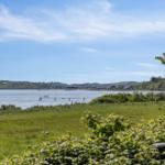 Grünes Feld mit Blick auf Wasser und Ferienort