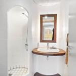 Badezimmer mit Dusche, Waschbecken und Spiegel.