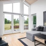 Living room with gray sofa, fireplace, and large windows to terrace.