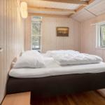 Bedroom with bed, windows, and wooden wall cladding.