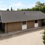 Single-family house with wooden siding and tiled roof. Surrounded by greenery and trees.