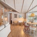 Living area with dining table, sofa, and sleeping area above