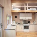 Kitchen with countertop, sink, stove, and refrigerator. Above sleeping area with mattresses.
