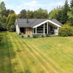 House with large garden and terrace surrounded by trees.