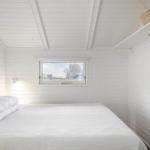 Schlafzimmer mit weißem Bett und Fensterblick