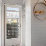 Eingangsbereich mit Tür, Fenster und Spiegel an der Wand.