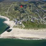 Luftbild eines Küstenorts mit Strand und markierter Lage.