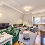 Wohn- und Essbereich mit Sofa, Stühlen und Küchenzeile.