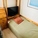 Ein Schlafzimmer mit Bett, Holzmöbel und Fernseher.