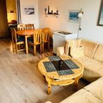 Wohnzimmer mit Sofa, Esstisch und Holzboden