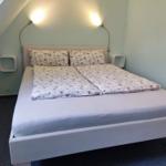 Schlafzimmer mit Doppelbett, floraler Bettwäsche und zwei Wandlampen.