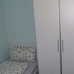 Schlafzimmer mit Einzelbett und weißem Schrank