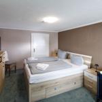 Schlafzimmer mit Doppelbett, Kleiderschrank und Babybett.