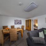 Wohn- und Essbereich mit Sofa, Esstisch und Blick in Schlafzimmer.