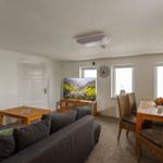 Wohn- und Essbereich mit Sofa, TV, Esstisch und Stühlen.