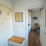 Eingangsbereich mit Garderobe, Bild und Fenster mit Vasen.