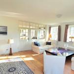 Wohnzimmer mit Sofa, Sessel, Couchtisch und Holzboden.