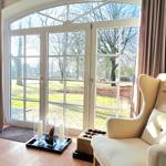 Lichtdurchfluteter Raum mit Sitzgelegenheiten und Blick auf den Garten.