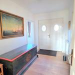 Eingangsbereich mit Holzboden, antikem Schrank und Wandgemälde