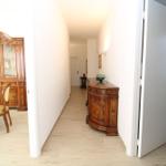Hallway with wooden flooring, antique cabinet, and sideboard