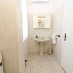 Bathroom with pedestal sink, mirror cabinet, and washing machine.