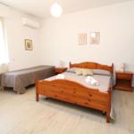 Bedroom with double bed, single bed, wardrobe, and nightstands.