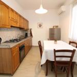 Kitchen with wooden cabinets, dining table, and kitchen counter.