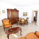 Living and dining area with wooden furniture and leather seating. 
