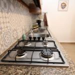 Kitchen with gas stove, sink, and mosaic wall