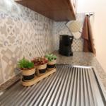 Kitchen counter with mosaic tiles, coffee machine, and potted plants.