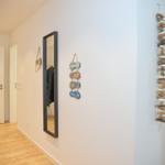 Flur mit Spiegel, Stranddekoration und Holzdekoration an der Wand.