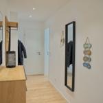 Flur mit Spiegeln, Kleiderständer und Wanddekoration.