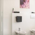 Badezimmer mit Dusche, Bidet und Toilette. Wandbild mit Lavendel.