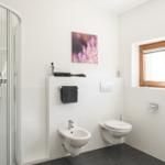 Badezimmer mit Dusche, WC und Fenster