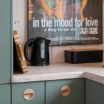 Kitchen area with coffee machine, kettle, and movie poster on the wall.