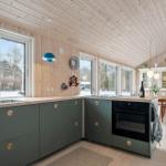 Kitchen with green cabinets, wooden ceiling, and view of snow.