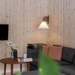 Living room with wooden wall, sofa, coffee table, and TV.