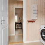 Laundry room with washing machine and heating control on wooden wall