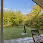 Deck with table, chairs, and fire pit in the garden.